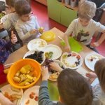 dzieci wykonują sałatkę owocową